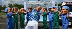 Oxfam activists wearing oversized masks pose during their "Big Heads" protest at Utinga Park in Belem in November 2025, to simulate a chaotic emergency room and highlight that as COP30 ends, the planet is in critical condition. 
