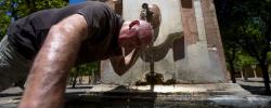 Un hombre se refresca en una fuente de Córdoba